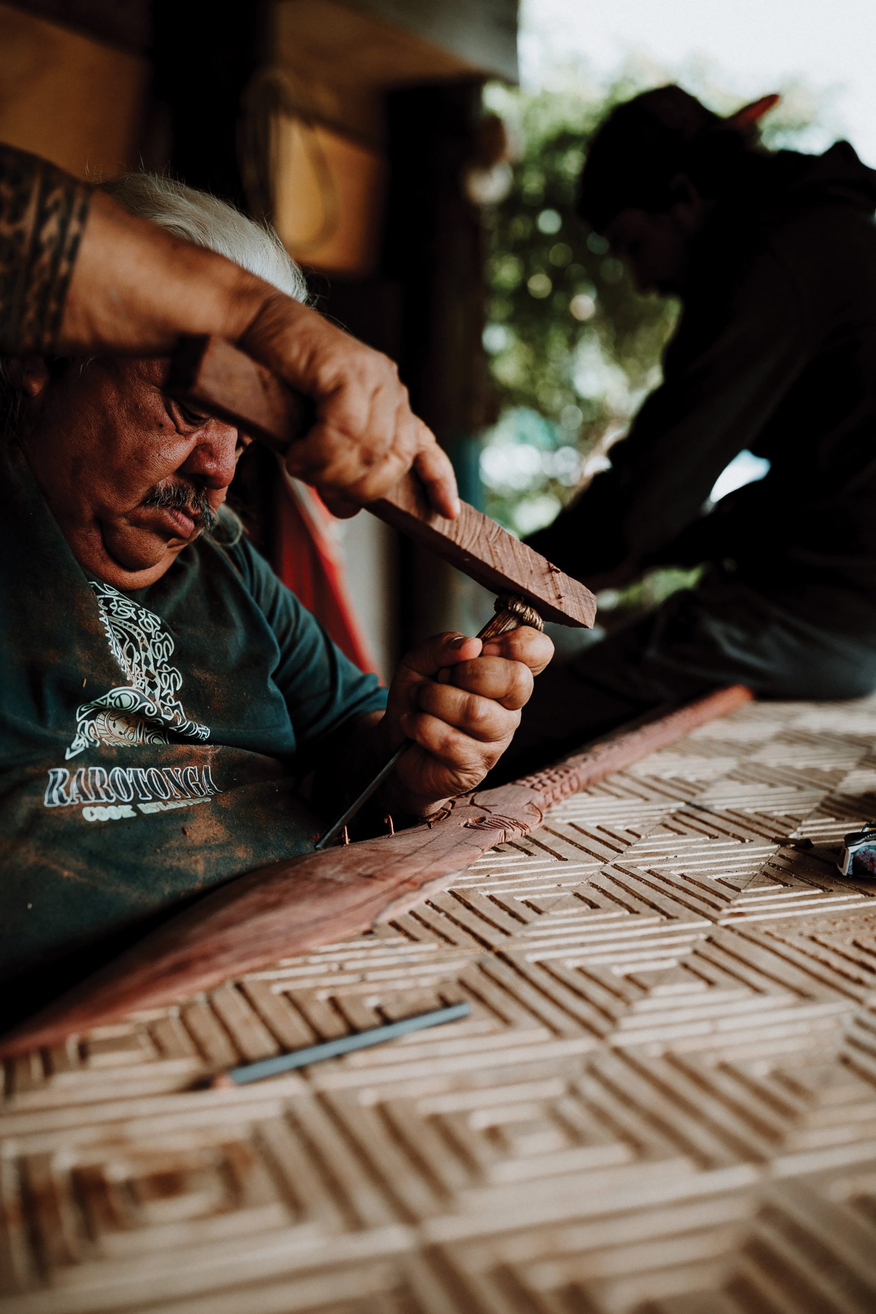     Alex King, Michael Tavioni carving a spear for a buyer, 2019. Courtesy of the artist.

