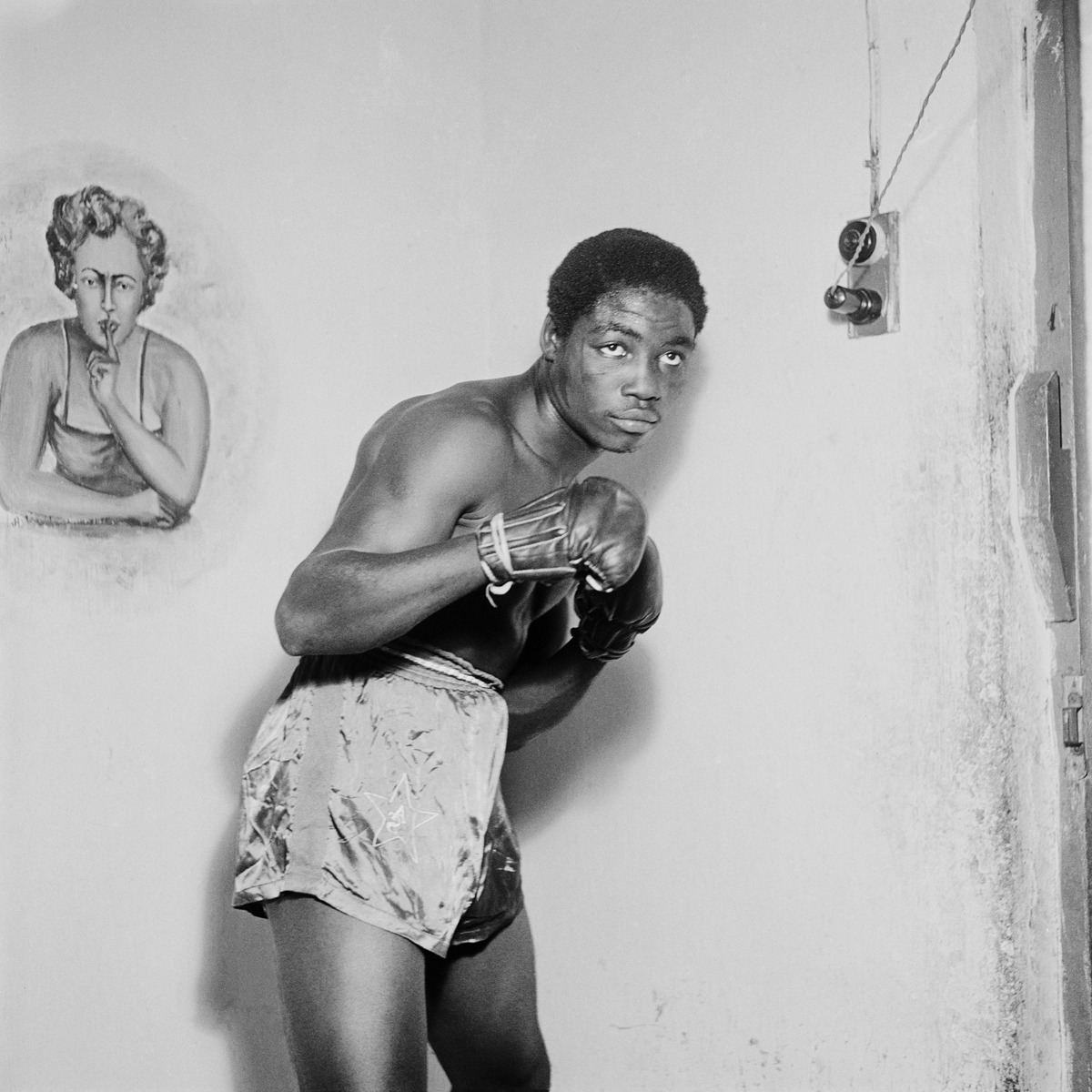     James Barnor, Ginger Nyarku Featherweight boxer with Coronation Belt, Accra, 1953. Gelatin silver print, 30 x 30&#8243;. Courtesy of Autograph ABP.

