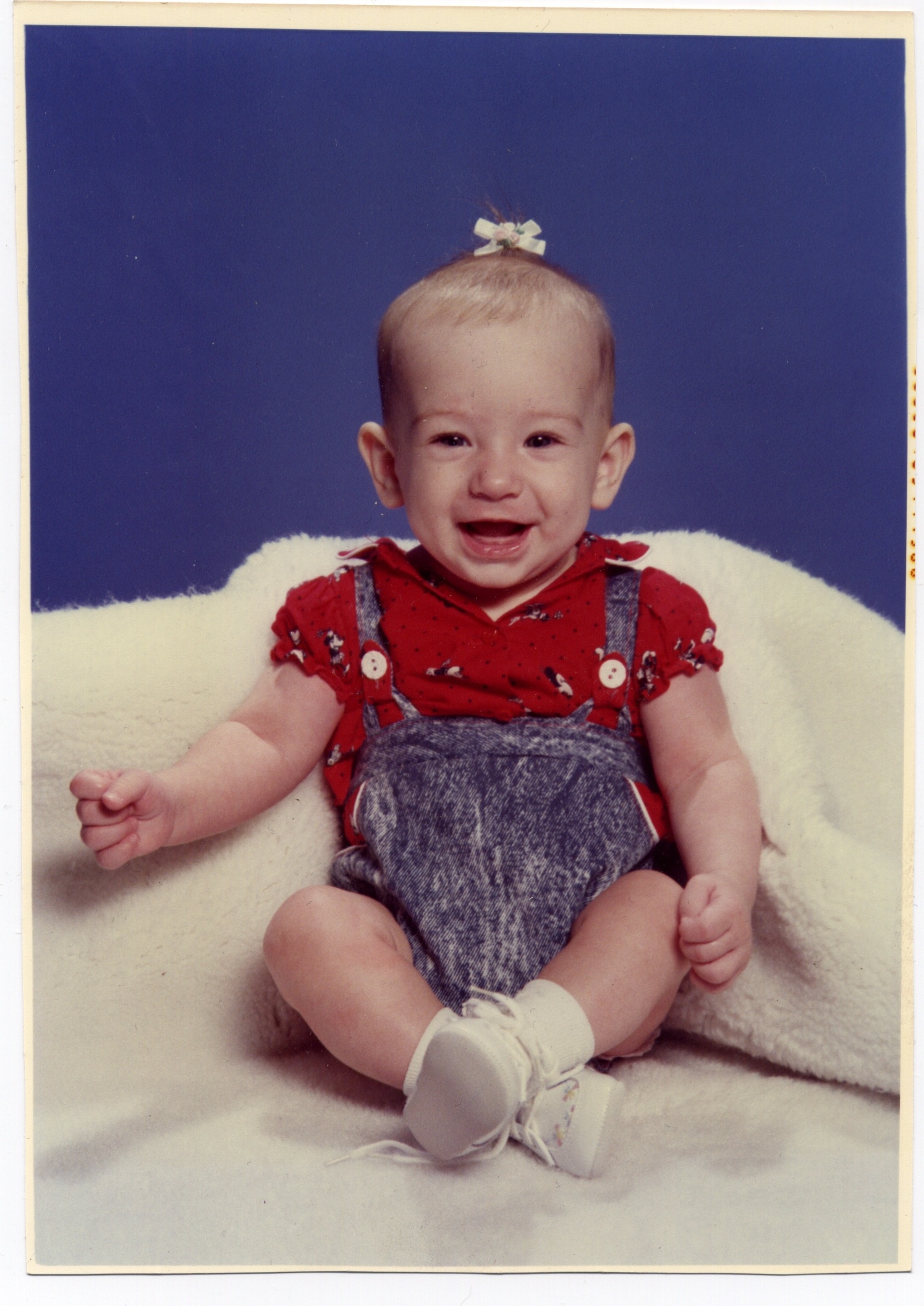     (unknown photographer), Baby with bow and acid-wash jumper, Circa 1990 

