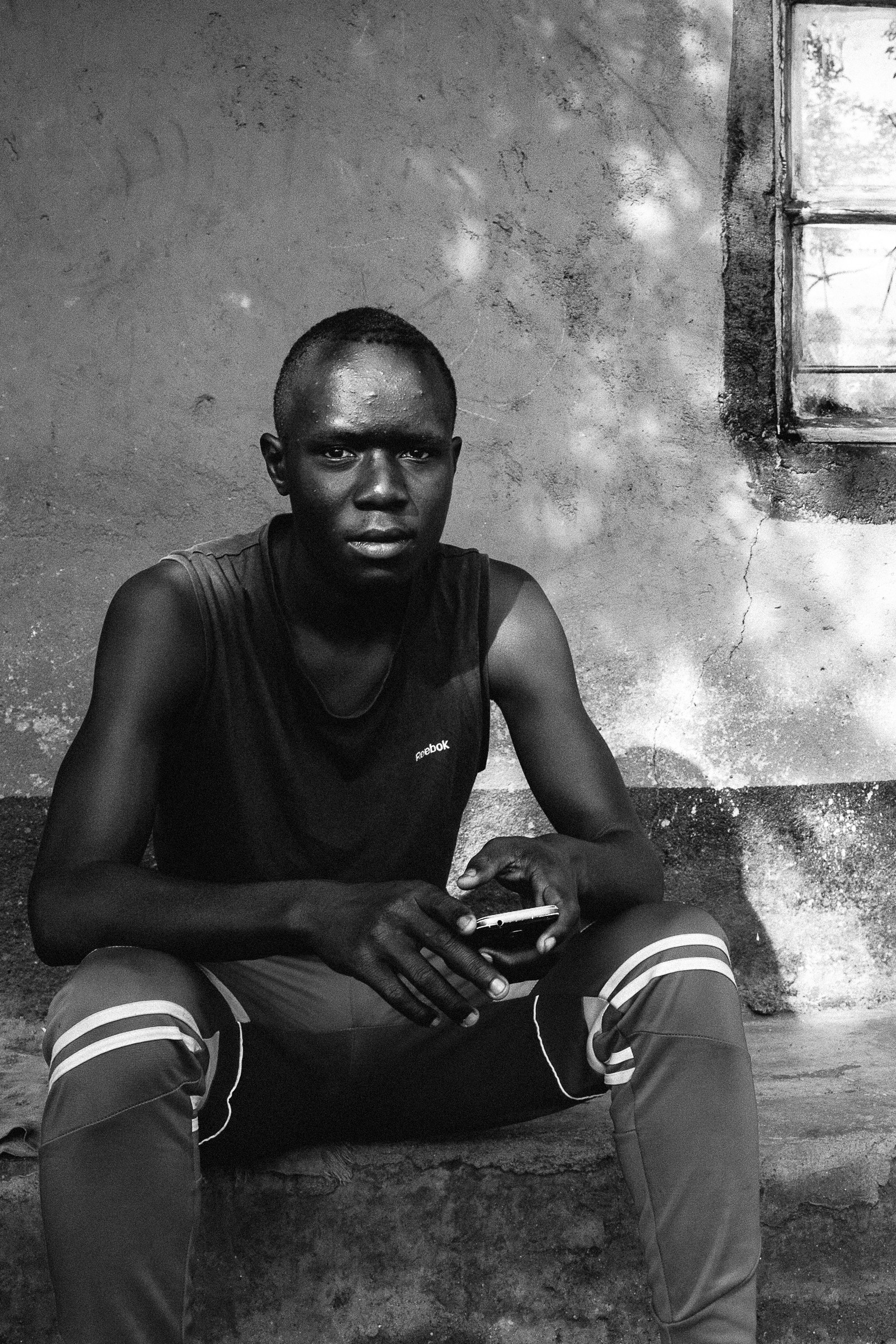 Leyla Jeyte, teen sitting outside of home with a phone, 2016. Courtesy of the artist