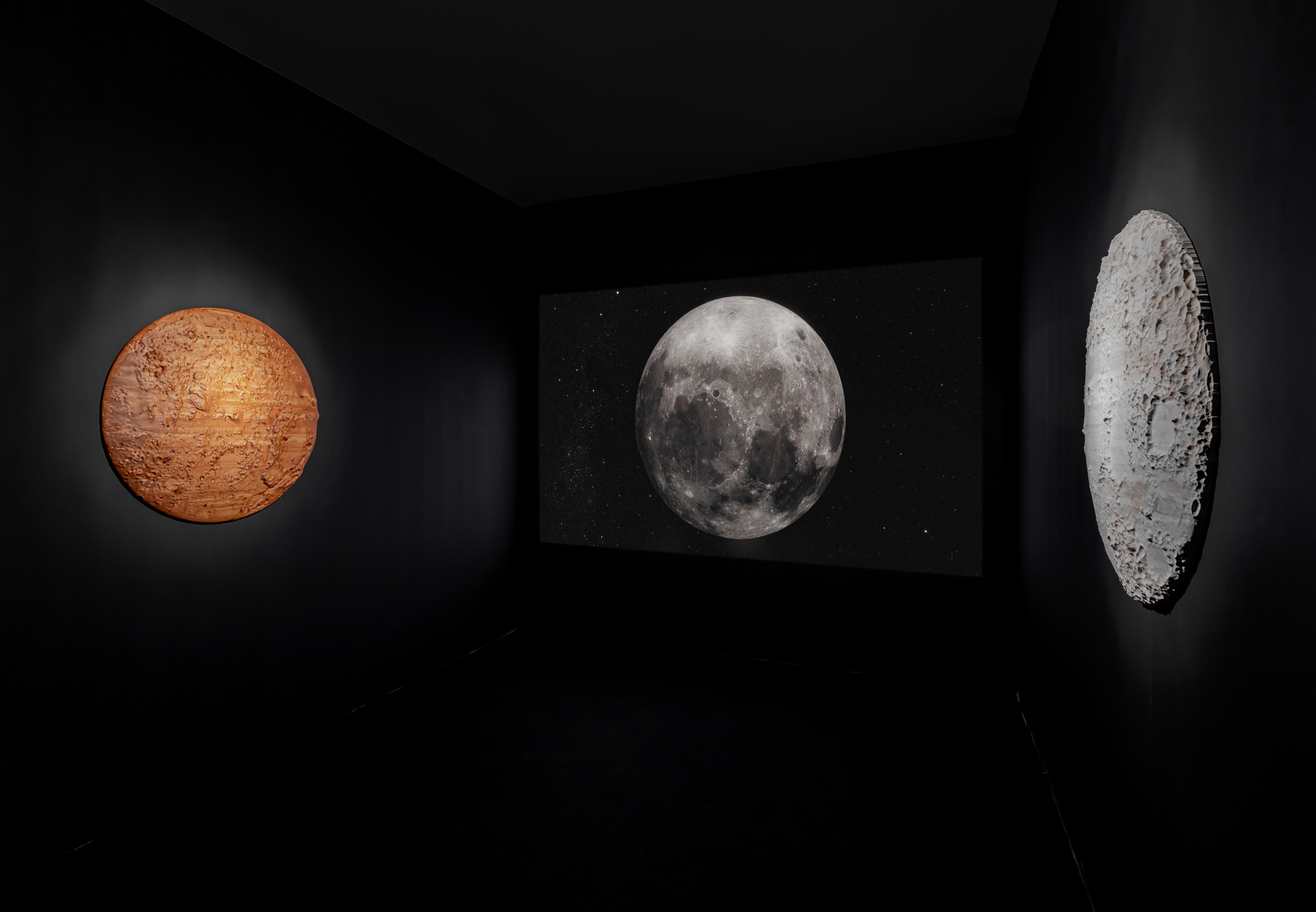     Sasha Huber, YOU NAME IT, installation view (&#8220;Space Race,&#8221; 2018. Installation with Moon and Mars sculptures (pine wood) and video, 4:00min. [3D visualization by Tuomas Kankola]), The Power Plant Contemporary Art Gallery, 2022. Courtesy of the artist and The Power plant. Photo: Toni Hafkenscheid

